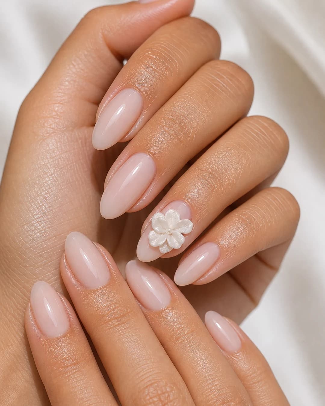 Uñas con una flor 3D blanca con pétalos esculpidos en builder gel