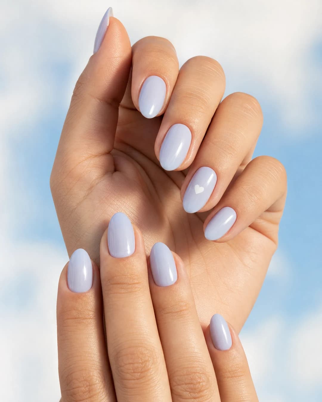 Uñas almendradas con blueberry milk y corazón mini blanco pintado a mano en el anular