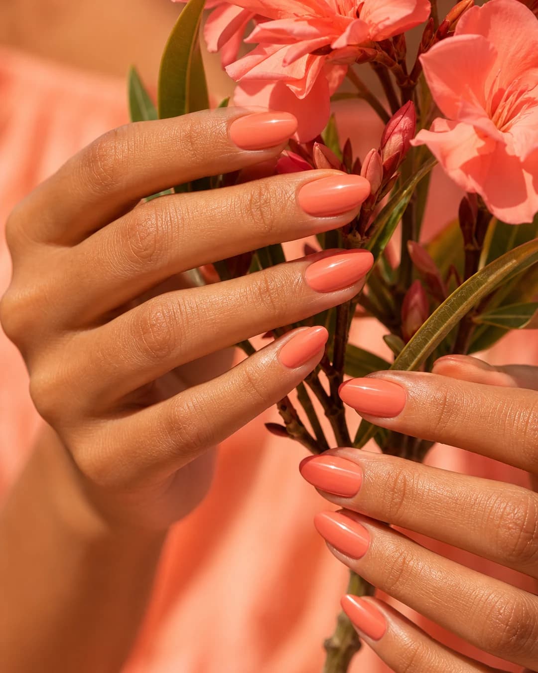 Uñas melocotón coral cálido para verano piel bronceada